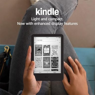 A person holding a Kindle displaying book covers on a grey background.
