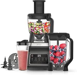 A multi-functional kitchen blender with various jars and attachments, filled with fruits and vegetables.