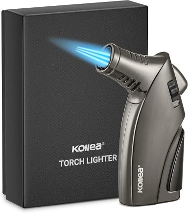 A silver torch lighter with a blue flame next to its black packaging.
