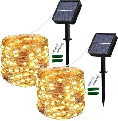Solar-powered fairy lights on a spool with two solar panels and stakes.