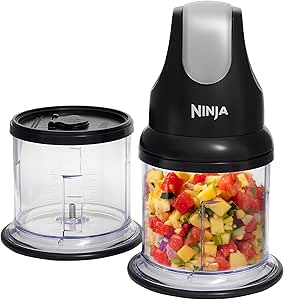 Ninja food processor with chopped vegetables in a clear bowl and a lid.