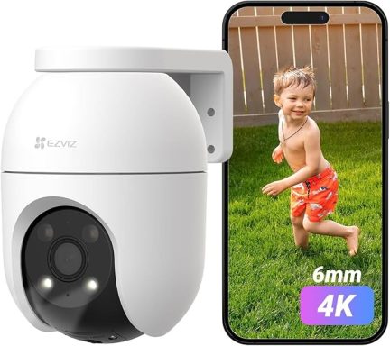 A security camera next to a smartphone showing a child playing in green grass.